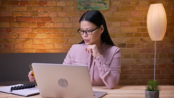 V kanceláři se střílejí dospělí asijští Obchodni psaní na notebook — Stock video