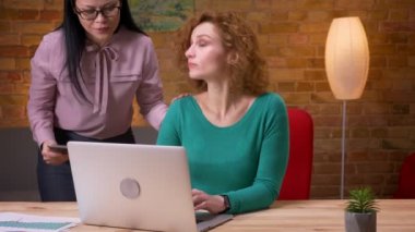 Ofiste kapalı dizüstü bilgisayarda yazarak yetişkin iş kadını closeup ateş. Kadın çalışan tablette kendi verileri ile siscussing