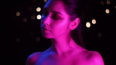 Kamera önünde poz pembe neon ışık ve bokeh arka plan ile genç çarpıcı kafkas kadın Closeup ateş