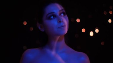 Mavi ve kırmızı neon ışık ve bokeh arka plan kamera önünde poz glitter makyaj ile genç güzel kafkas kadın Closeup ateş