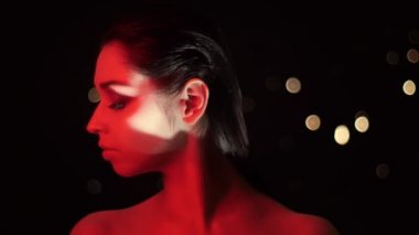 Kamera önünde poz kırmızı neon ışık ve bokeh arka plan ile çarpıcı glitter makyaj ile güzel kadın Closeup ateş