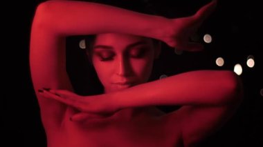 Kamera önünde poz kırmızı neon ışık ve bokeh arka plan ile çarpıcı makyaj ile oldukça seksi kadın Closeup ateş