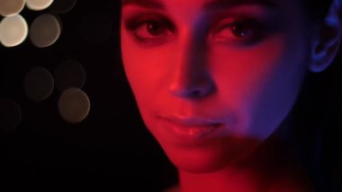 Kamera bakarak kırmızı neon ışık ve bokeh arka plan ile çarpıcı vogue makyaj ile güzel kadın yüz Closeup ateş