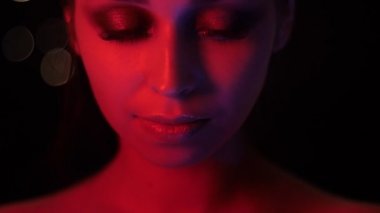 Kamera önünde poz kırmızı neon ışık ve bokeh arka plan ile çarpıcı vogue makyaj ile güzel kadın yüz Closeup ateş