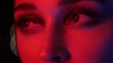 Gece kulübünde kırmızı neon ışık ve bokeh arka plan ile baştan çıkarıcı vogue makyaj ile güzel kadın gözleri Closeup ateş