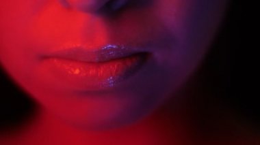 Gece kulübünde kırmızı neon ışık ve bokeh arka plan ile güzel kadın baştan çıkarıcı dudaklar Closeup ateş