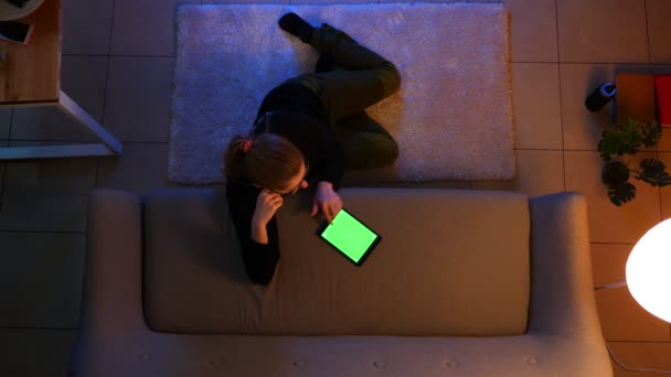 Close up top shoot of pretty female using the tablet and shopping online while sitting on the floor indoors in a cozy apartment — стоковое видео