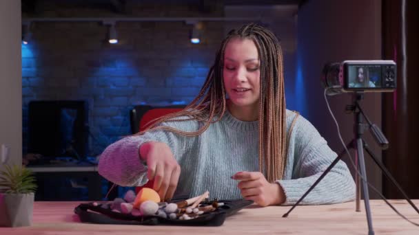 Dreadlocks canlı ve reklam kozmetik kapalı neon arka plan ile akarsu ile genç çekici kadın blogger Closeup ateş — Stok video