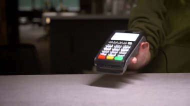 Temassız ödeme yapan terminal ve kredi kartı kullanan kişinin yakın çekim çekimi.