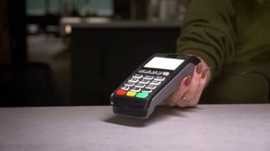 Terminal ve kredi kartı kullanan kişinin yakın çekim çekimi temassız ödeme yapar ve çeki yazdırır.
