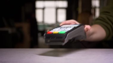 Terminal makinesi ile kredi kartı kaydıran adamın yakın çekim ödeme gerçekleştirme.