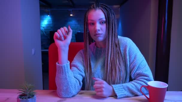 Dreadlocks canlı akışı ve konuşma ve neon arka plan kapalı mutlu gülümseyen ile genç çekici kadın blogger Closeup ateş — Stok video