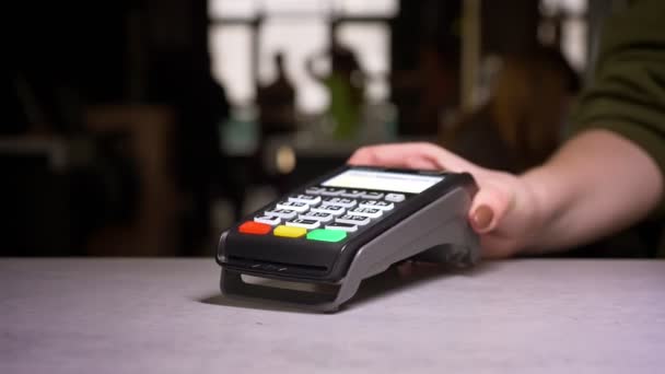 Gros plan de la personne glisse la carte de crédit à travers la machine de terminal effectuant le paiement . — Video