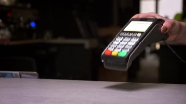 Adamın yakın çekim başarılı temassız ödeme gerçekleştiren terminal için cep telefonu uygular.
