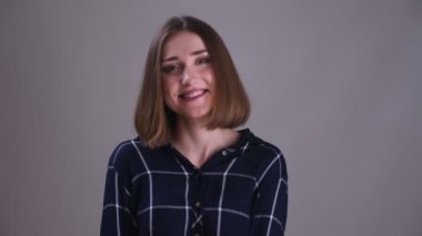 Kamera bakarak ve gri izole arka plan ile mutlu gülümseyen genç oldukça kısa saçlı kadın Closeup ateş