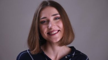 Genç oldukça kısa saçlı kadın yüz closeup ateş arka plan gri izole ile gülümseyen yüz ifadesi ile kameraya bakarak