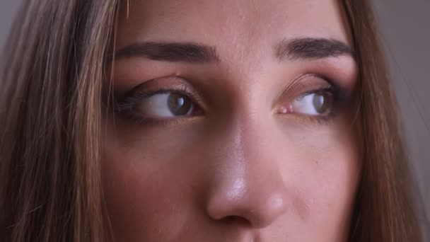 Closeup shoot of young beautiful female face with eyes looking to the side with smiling facial expression — Stock Video