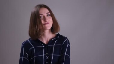 Kamera bakarak ve gri izole arka plan ile komik yüz ifadeleri yapma gülümseyen genç oldukça kısa saçlı kadın Closeup ateş