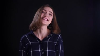 Genç sevimli kısa saçlı kadın Closeup ateş kamera düz bakıyor ve siyah izole arka plan ile utangaçlık ile gülümseyerek