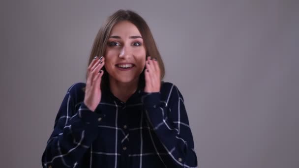 Genç oldukça kısa saçlı kadın kamera gülümseyerek bakarak ve gri izole arka plan ile mutlu bir şekilde gülüyor Closeup ateş — Stok video