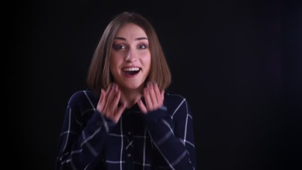 Closeup shoot of young pretty short haired female getting excited and surprised looking straight at camera with background isolated on black — Stock Video