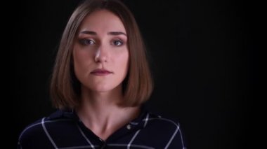 Siyah izole arka plan ile utangaç yüz ifadesi ile gülümseyen kameraya düz bakarak genç oldukça kısa saçlı kadın yüz Closeup ateş