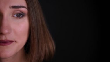 Siyah izole arka plan ile neşeyle gülümseyen kameraya düz bakarak genç oldukça kısa saçlı kadın yüz Closeup yarım yüz çekimi