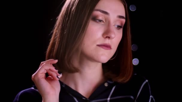 Close-up shoot van jonge mooie korte haired vrouw poseren in de voorkant van de camera met bokeh achtergrond — Stockvideo