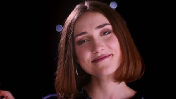 Close-up tiro de jovem muito curto cabelo feminino sorrindo alegremente olhando para a câmera com luzes bokeh no fundo — Vídeo de Stock