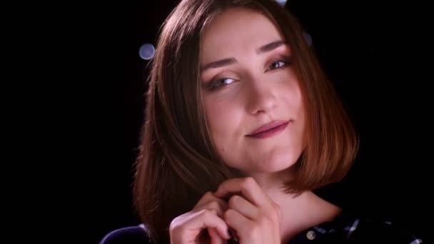 Nahaufnahme von jungen hübschen kurzhaarigen Frauen, die lächelnd in die Kamera schauen, mit Zärtlichkeit und Bokeh-Lichtern auf dem Hintergrund — Stockvideo