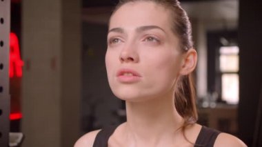 Bir at kuyruğu ile genç çekici atlet kadın Closeup ateş kapalı spor salonunda egzersiz için hazırlanıyor