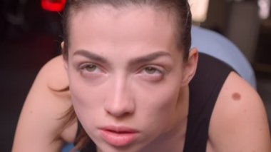 Genç çekici atlet kadın kapalı spor salonunda kamera önünde bir tahta ayakta Closeup ateş