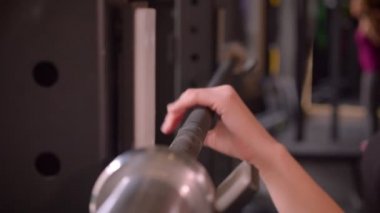 Genç çekici atlet kadın ellerin closeup yan görünüm ateş kapalı spor salonunda ağırlık kaldırmaya hazırlanıyor