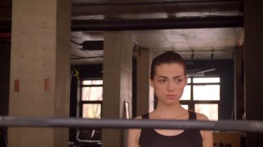 Genç çekici atlet kadın yürüyüş closeup ateş ve salonda ağırlık kaldırmaya hazırlanıyor