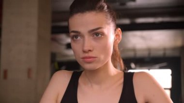 At kuyruklu genç çekici atlet kadın kapalı spor salonunda kararlılıkla orbitrek üzerinde çalışan Closeup ateş