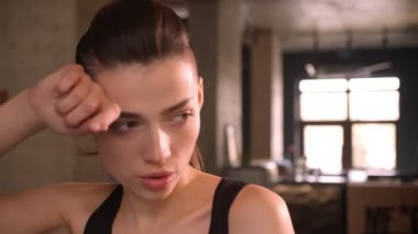 At kuyruklu genç çekici atlet kadın closeup ateş orbitrek üzerinde kamera bakarak ve salonda salonda terleme üzerinde çalışma