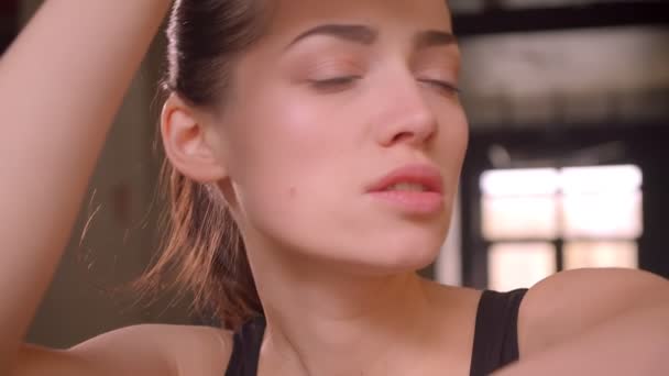 Close-up tiro de jovem atleta atraente feminino trabalhando fora e suando no ginásio dentro de casa — Vídeo de Stock