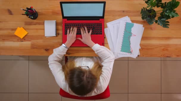 Primo piano ripresa superiore della giovane donna d'affari caucasica in occhiali utilizzando il computer portatile sulla scrivania al chiuso in ufficio — Video Stock