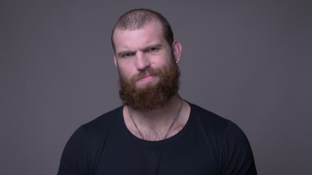 Gros plan tige de adulte beau musclé caucasien homme avec barbe agitant sa tête en disant non regardant caméra avec fond isolé sur gris — Video