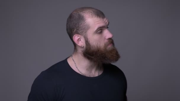 Close-up shoot van volwassen knappe gespierde blanke man met baard dansen wordt ontspannen in de voorkant van de camera met achtergrond geïsoleerd op grijs — Stockvideo