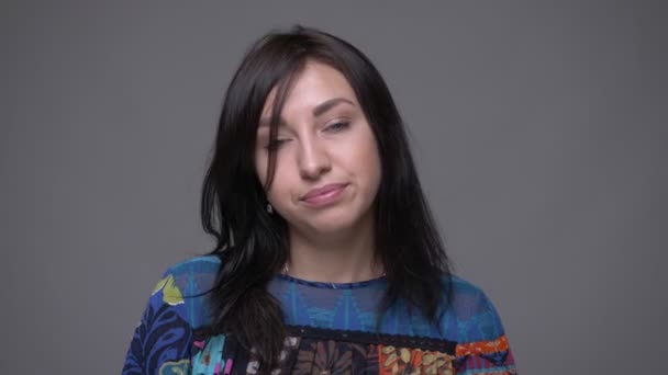 Портрет крупным планом взрослой брюнетки кавказской женщины, которая кивает, говоря "да", глядя на камеру с изолированным на сером фоне — стоковое видео