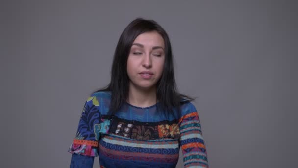 Retrato de close-up de adulto caucasiano morena mulher cutucando com confiança na frente da câmera com fundo isolado em cinza — Vídeo de Stock