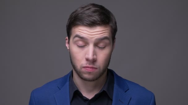 Closeup lő a fiatal csinos kaukázusi ember bólogat mondás igen és néztem kamera háttérrel izolált szürke — Stock videók