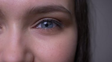 Mavi pırıl pırıl göz ile genç mutlu çekici kadın yüz Closeup yarım yüz çekimi gülümseyen yüz ifadesi ile kameraya bakarak.