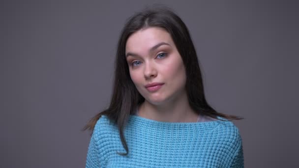 Närbild shoot av unga Söt brunett kvinna gör roliga ansiktsuttryck tittar på kamera med bakgrund isolerad på grå — Stockvideo