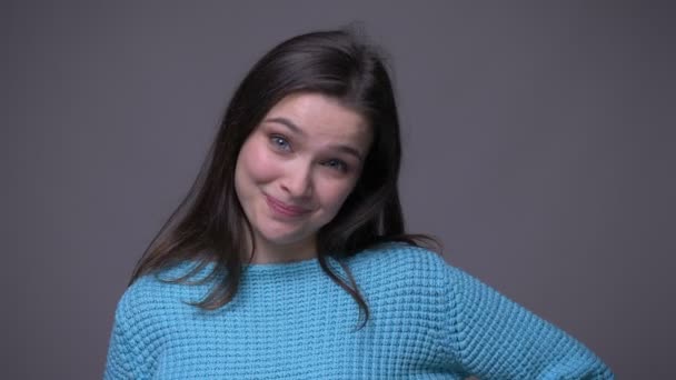 Closeup shoot of young pretty brunette female gesturing okay handsign smiling and looking at camera with background isolated on gray — Stock Video