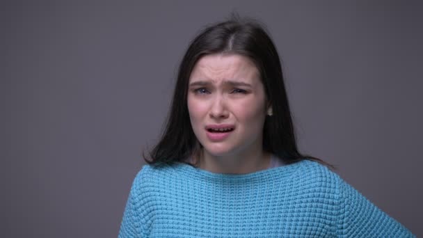Close-up shoot van jonge mooie brunette vrouw beschaamd en geïrriteerd klappen haar HAED met een hand kijken naar camera met achtergrond geïsoleerd op grijs — Stockvideo