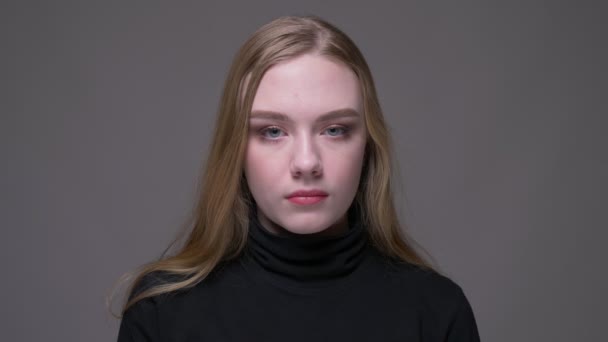 Closeup portrait of young attractive brunette female looking at camera with background isolated on gray — Stock Video