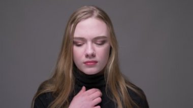 Hasta bir boğaz olan genç çekici esmer kadın Closeup portre ve gri izole arka plan ile hasta olmak