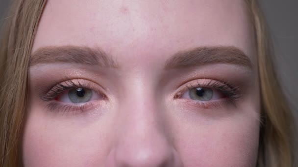 Close-up tiro de jovem atraente rosto feminino com olhos olhando para a câmera sendo aberto e fechado em movimento — Vídeo de Stock